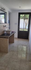 ein Badezimmer mit Waschbecken und großem Fenster in der Unterkunft El Esparragal Santa Clara del Mar in Santa Clara del Mar