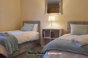 a bedroom with two beds and a mirror at Beach Braunton Spacious 3 Bed House By Dreamy Homes Short Lets & Serviced Accommodation Free Parking in Braunton