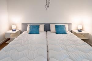 ein Schlafzimmer mit einem großen Bett mit blauen Kissen in der Unterkunft HM - HouseMirage in Paço de Arcos