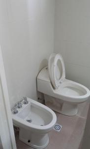 ein weißes Badezimmer mit Toilette und Waschbecken in der Unterkunft El Esparragal Santa Clara del Mar in Santa Clara del Mar