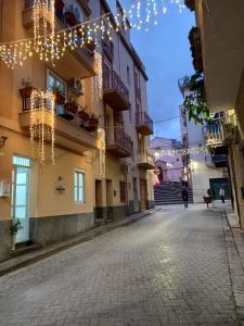 une rue vide avec des lumières de Noël suspendues à des bâtiments dans l'établissement Regina Stella, à Lascari