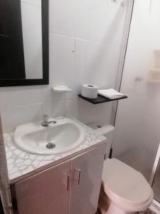 ein weißes Bad mit einem Waschbecken und einem WC in der Unterkunft Alojamiento Monik in Ríohacha