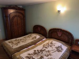 1 Schlafzimmer mit 2 Betten und einem Holzschrank in der Unterkunft House Ararat for rent, дом в аренду in Yerevan