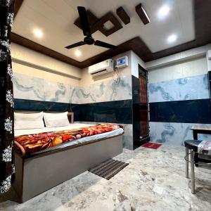 um quarto com uma cama grande e uma ventoinha de tecto em Hotel Raghunandan Near Shree Ram Janambhumi em Ayodhya