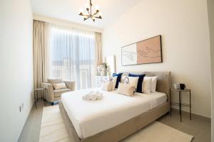 una camera con un grande letto bianco e una sedia di Veluxa - Luxe 2Bed in Downtown! a Dubai