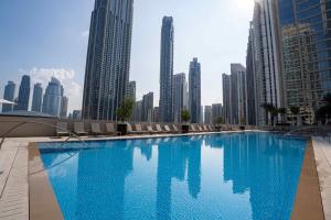 una grande piscina in una città con edifici alti di Veluxa - Luxe 2Bed in Downtown! a Dubai