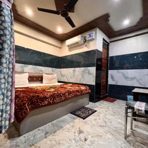 um quarto com uma cama e uma ventoinha de tecto em Hotel Raghunandan Near Shree Ram Janambhumi em Ayodhya