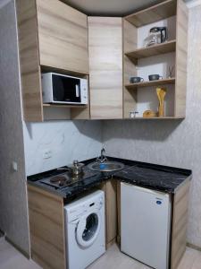 アルマトイにあるОтличная квартира со всеми удобствами.の小さなキッチン(洗濯機、電子レンジ付)