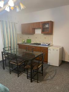 a kitchen with a glass table and chairs and a stove at Hygge House in Buşteni +2 photos