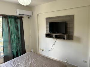 a bedroom with a bed and a tv on the wall at Apart Momias del Llullaillaco II Anexo Av. Belgrano in Salta