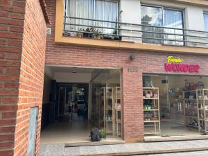 a store front of a brick building with a window at Apart Momias del Llullaillaco II Anexo Av. Belgrano in Salta