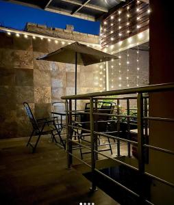 a patio with a table and an umbrella and chairs at Hidden house in Mexico City