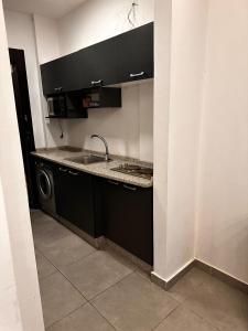 a kitchen with a sink and a washing machine at Gentle Breeze Studio1 in Amman