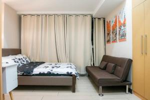 a small bedroom with a bed and a couch at A2J Luxury 1BR Suite Near Uptown Mall BGC Taguig in Manila