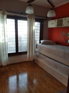 1 dormitorio con 2 camas y 2 ventanas grandes en Casa faro de Evangelina en Mar del Plata