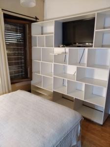 1 dormitorio con estanterías blancas y 1 cama en Casa faro de Evangelina en Mar del Plata