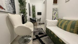 a living room with a white chair and a couch at A home in the center of Athens in Athens