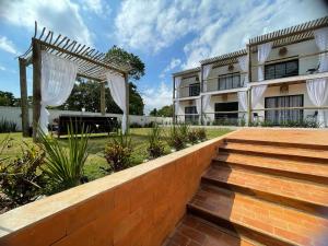 een extern uitzicht op een huis met een hek en een trap bij Santomar Guest House in Ilhabela