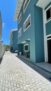 a blue building with a stone driveway in front of it at Residencial Maria Idia in Bombinhas