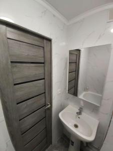 a bathroom with a sink and a toilet and a mirror at Отличная квартира со всеми удобствами. in Almaty