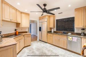 a kitchen with wooden cabinets and a ceiling fan at Groovy Getaway! Heated pool! Something different in Cape Coral
