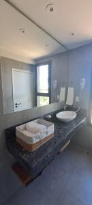 a bathroom with a sink and a large mirror at La Viñita Wine Lodge in San Carlos