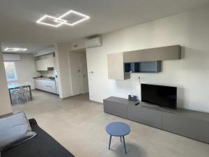 uma sala de estar com televisão e um banco azul em Villa Primule Cattolica em Cattolica