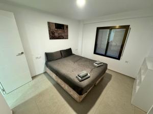 1 dormitorio con 1 cama en una habitación con ventana en Piso nuevo al lado del mar, en Valencia