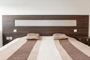 Un dormitorio con una cama grande con dos almohadas encima. en KAN Suites 1, en Belgrado