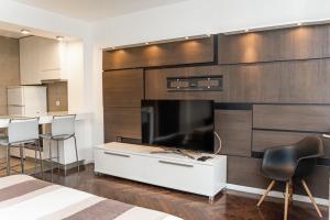 1 dormitorio con TV grande y armario blanco en KAN Suites 1, en Belgrado