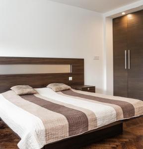 Un dormitorio con una cama grande con cabecero de madera. en KAN Suites 1, en Belgrado