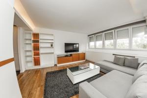 - un salon avec un canapé et une télévision dans l'établissement KAN Suites, à Belgrade