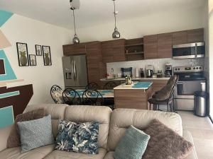 a living room with a couch and a kitchen at Villa Inoa en Playa Jaco in Jacó