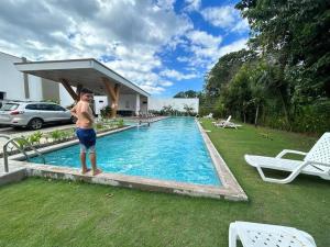 a man standing next to a swimming pool at Villa Inoa en Playa Jaco in Jacó