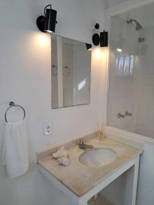 uma casa de banho com um lavatório e um espelho em Pousada dos Pássaros Geribá em Búzios
