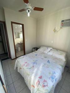 - une chambre avec un lit et un ventilateur de plafond dans l'établissement AP de praia com sacada, churrasqueira e garagem, à Balneário Camboriú