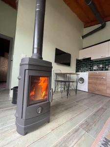 a stove in a living room with a table at Gökler Çiftliğinde Ekolojik Tatil in Foca