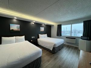 溫尼伯的住宿－Travelodge by Wyndham Winnipeg，酒店客房设有两张床和窗户。