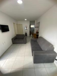 a living room with a couch and a tv at Condomínio encantador in Caruaru
