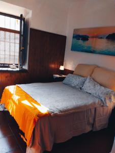 a bedroom with a bed with an orange blanket at Casa del agua in Granada