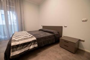 a bedroom with a bed and a dresser and a window at Casa Vacanza Rimini in Rimini