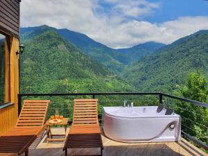 una vasca da bagno su una terrazza con 2 sedie di Villa Machakhela a Batumi
