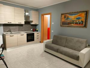 a living room with a couch and a kitchen at House IL CORALLO in Castrezatto