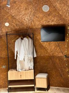 a room with a wooden wall with a shirt and a tv at Sphere Borjomi in Borjomi