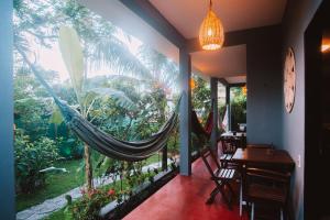 a hammock in a restaurant with a view of the garden at La Serena Hostel in Pipa