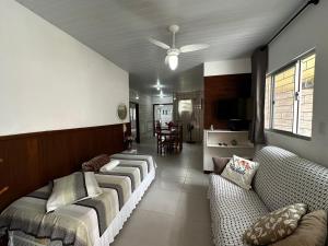 ein Wohnzimmer mit Sofas und einem Deckenventilator in der Unterkunft Ampla casa térrea, WiFi, estacionamento e segurança in Florianópolis