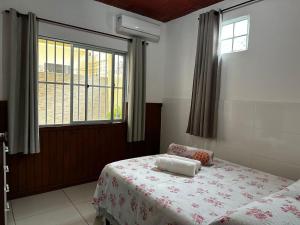 1 dormitorio con cama y ventana en Ampla casa térrea, WiFi, estacionamento e segurança, en Florianópolis