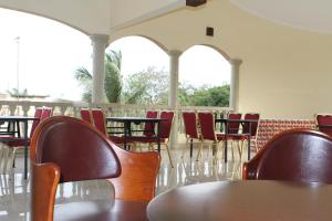 un grupo de mesas y sillas en una habitación en Hotel Residence Flamani, en Lomé