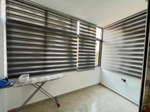 Habitación con 2 ventanas con persianas. en Tirana AS Apartment 1, en Tirana