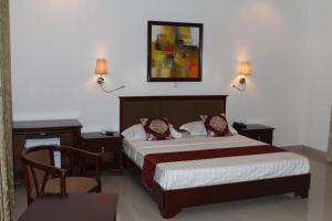 a bedroom with a bed and two lamps and a table at Hotel Residence Flamani in Lomé
